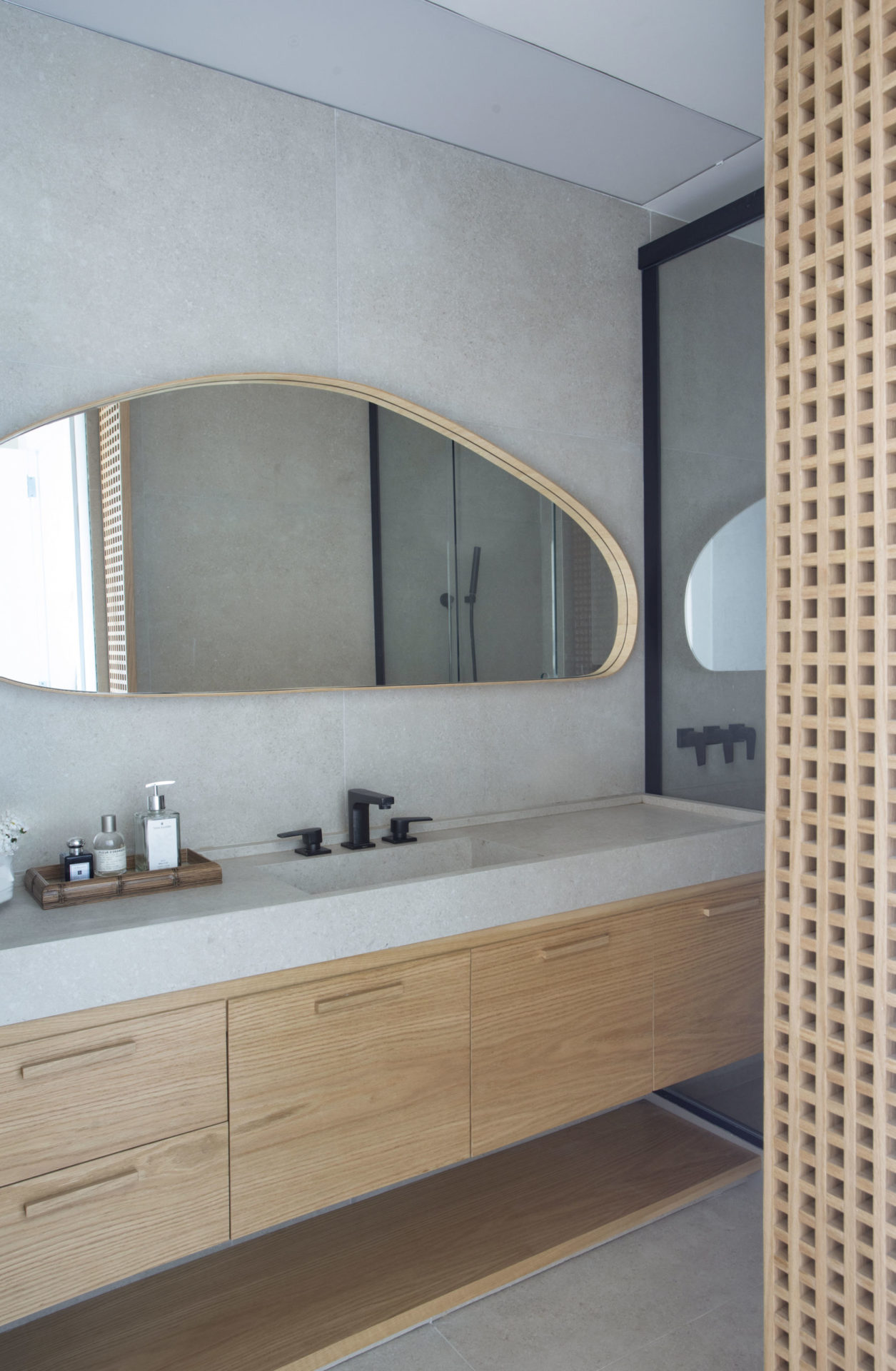 na foto banheiro com espelho e armário de madeira clara