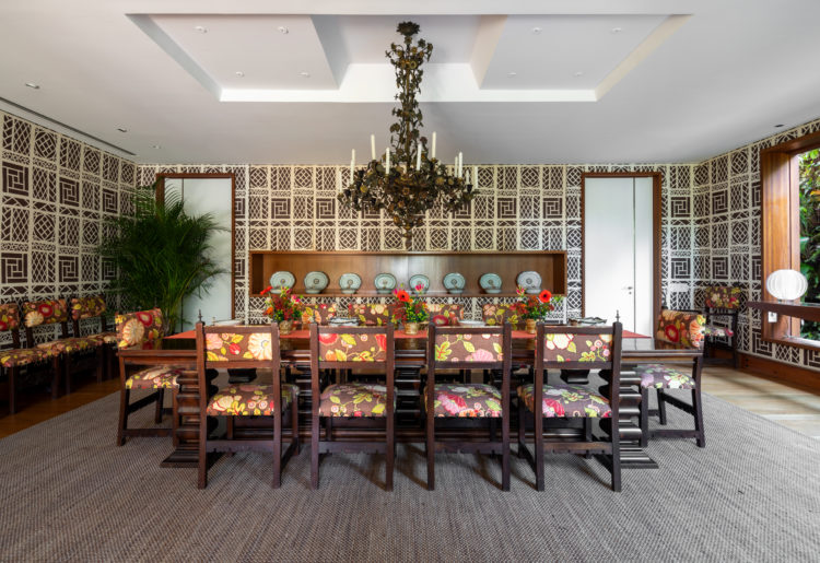 Ambiente de sala de jantar, com cadeiras estofadas no tecido estofada. 