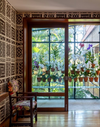 Uma pequena varanda com varios potes de orquideas. 