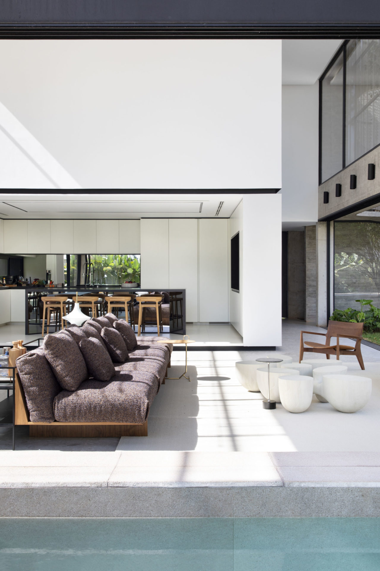 na foto interior de casa em estilo modernista com sala e piscina