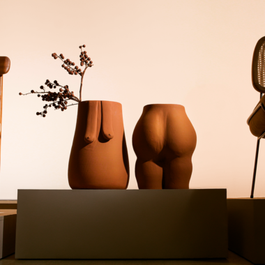 na foto objetos de cerâmica em formatos do corpo feminino e duas cadeiras