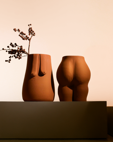 na foto objetos de cerâmica em formatos do corpo feminino e duas cadeiras