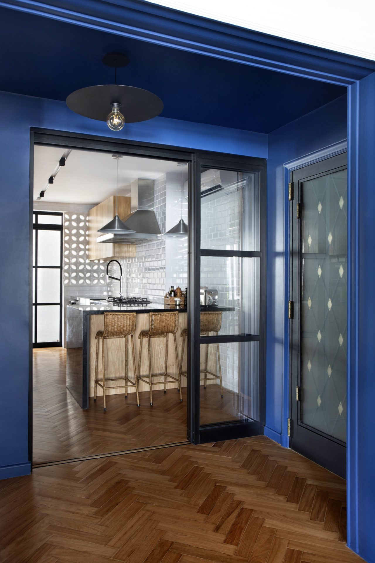 na foto corredor de apartamento na cor azul bic e cozinha