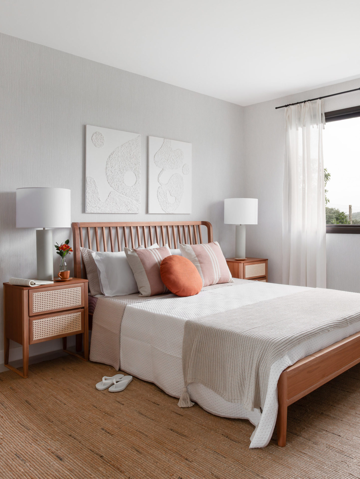 quarto de casal com cama, mesas de cabeceira e quadros na oarede