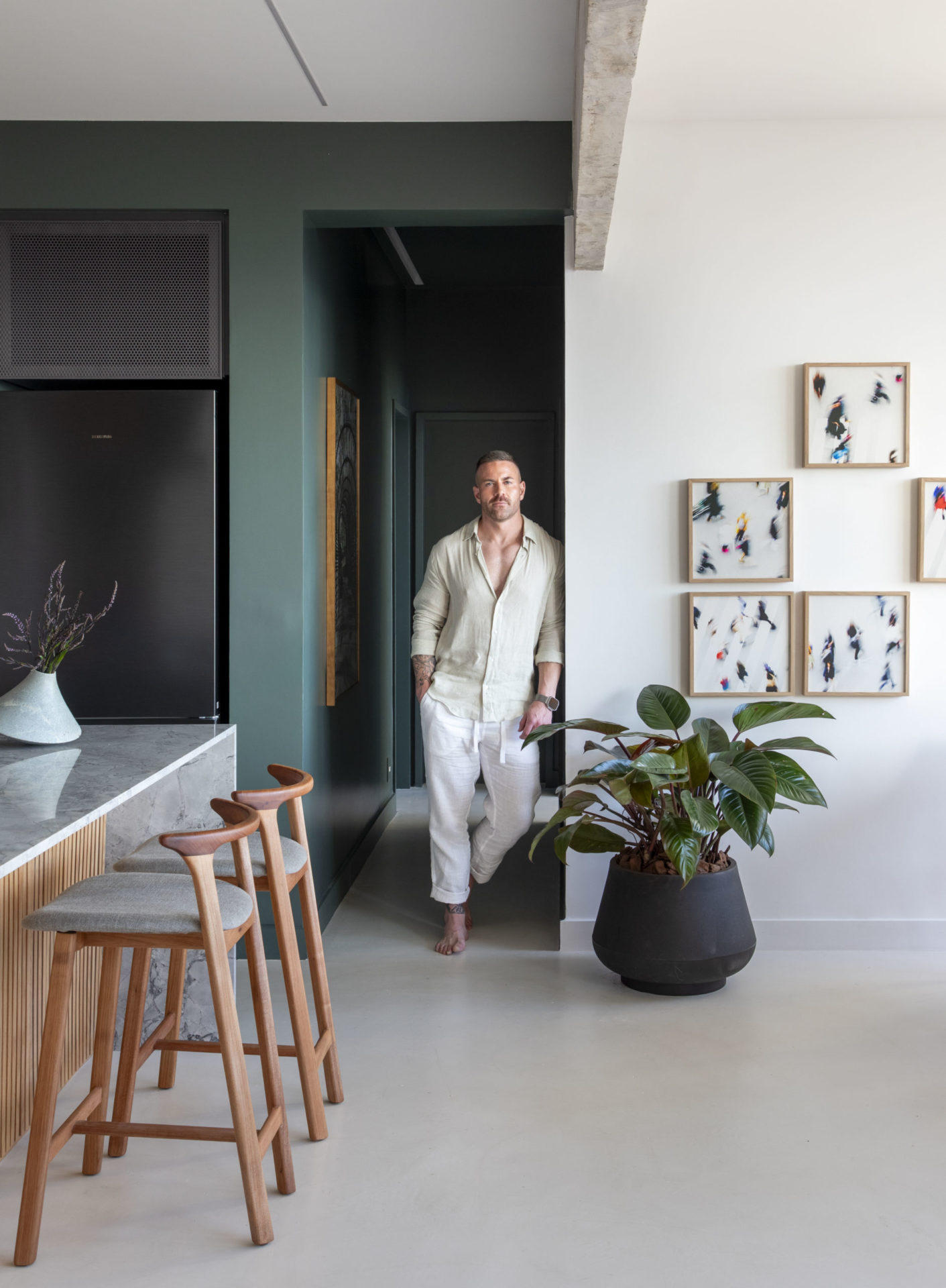 na foto home branco em pé na sala de seu apartamento em Ipanema