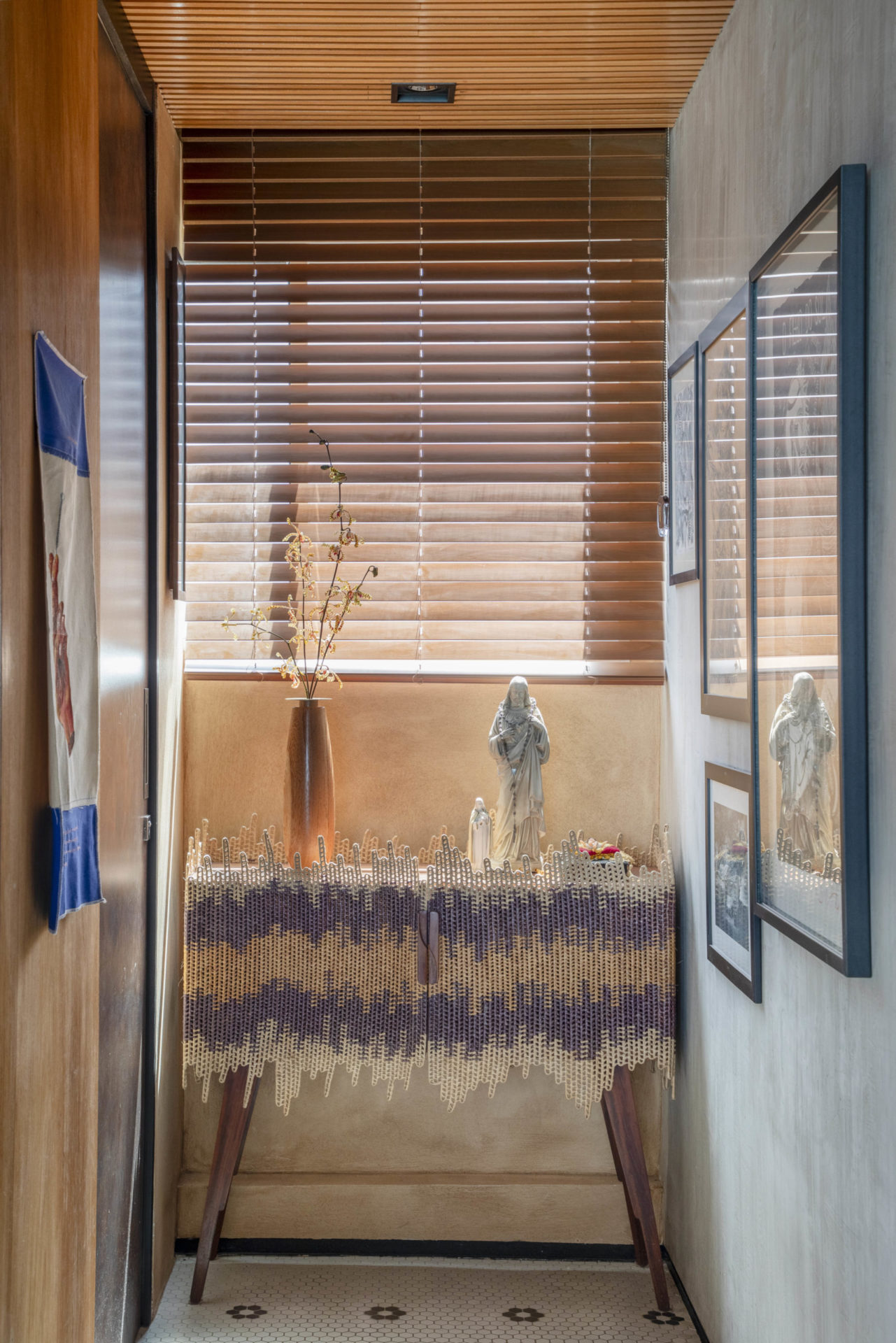 na foto canto de apartamento com janela e obras de arte
