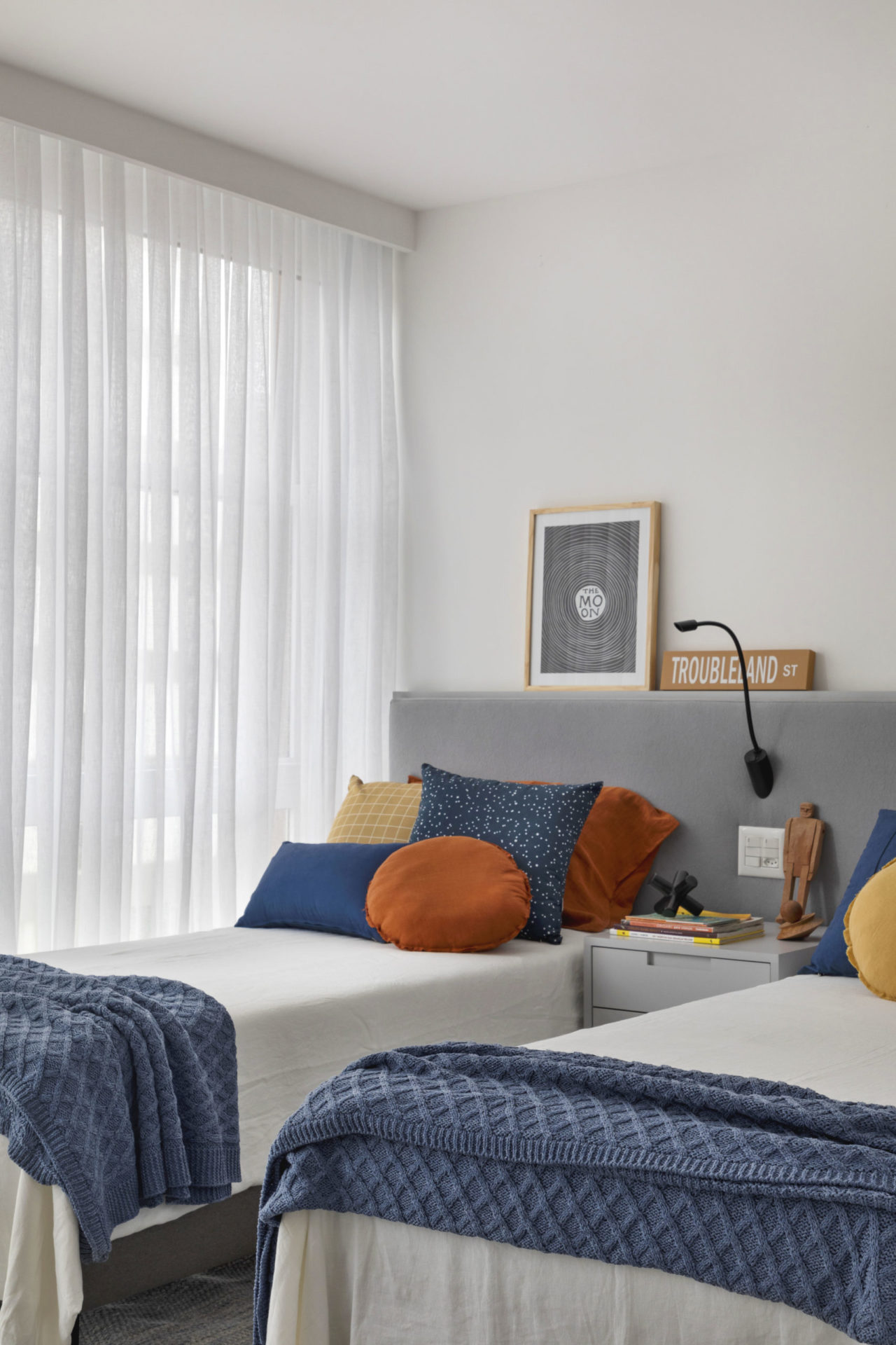 na foto quarto com duas camas e janela com cortina