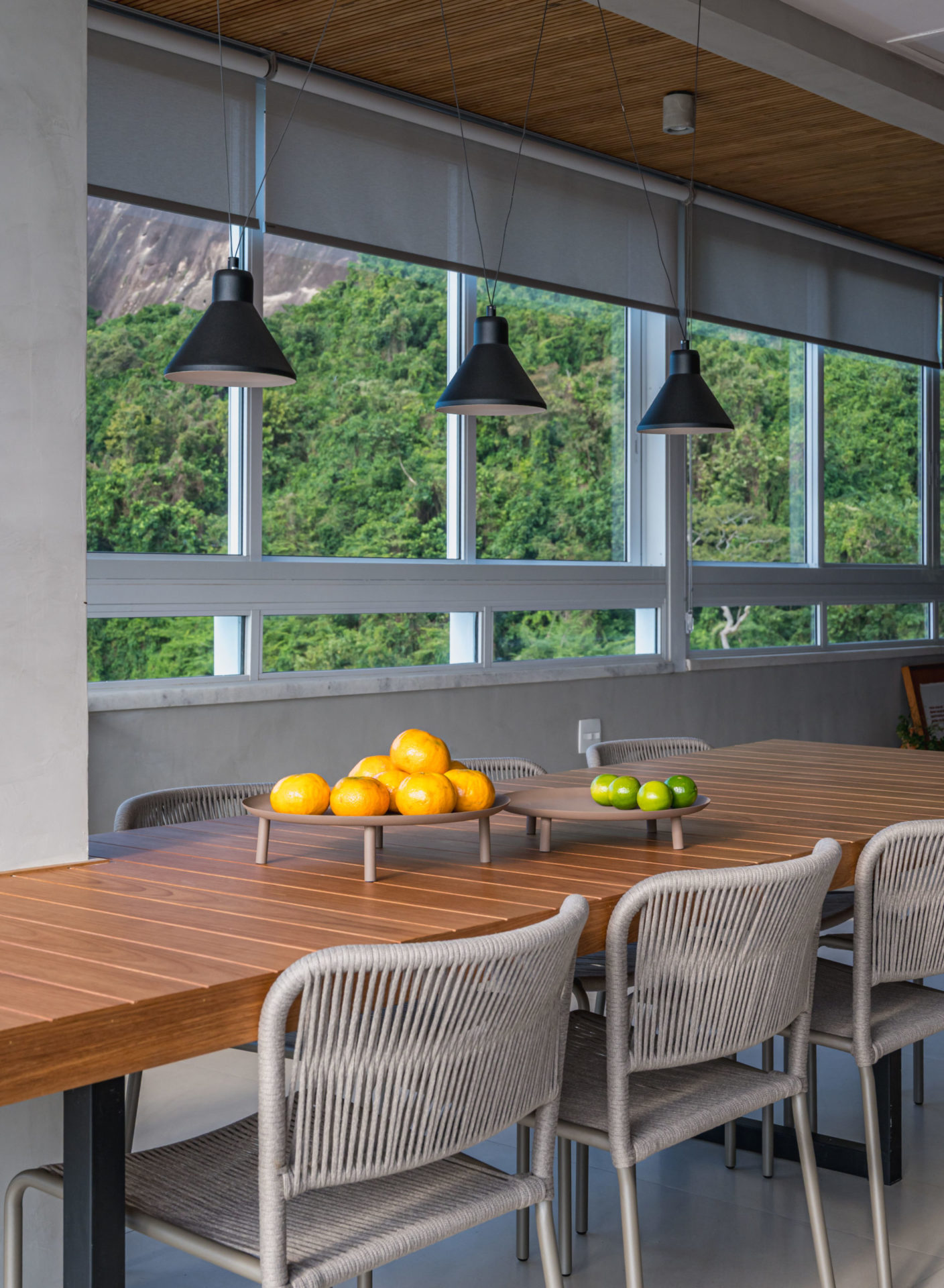 na foto sala com mesa de jantar e luminárias pendentes