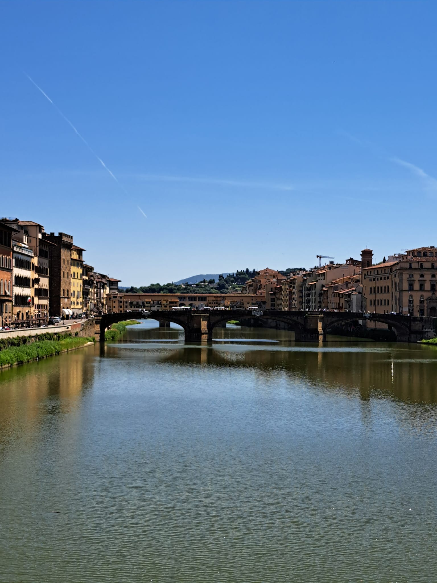 na foto céu azul e o rio Arno que atravessa a capital da Toscana. No fundo, a Ponte Vecchio.