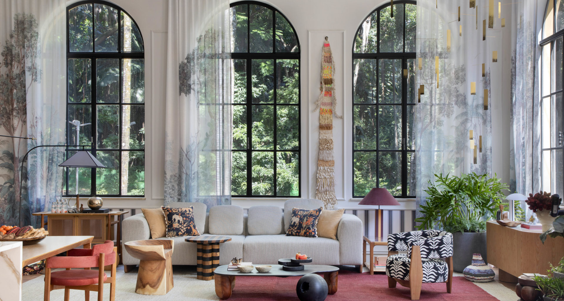 na foto visão ampla do loft carmim de paula neder com quatro grandes janelas e cortinas, cozinha e sala