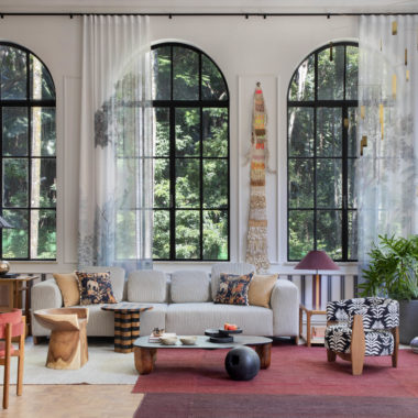 na foto visão ampla do loft carmim de paula neder com quatro grandes janelas e cortinas, cozinha e sala