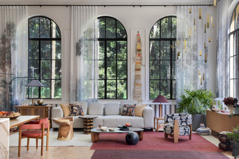 na foto visão ampla do loft carmim de paula neder com quatro grandes janelas e cortinas, cozinha e sala