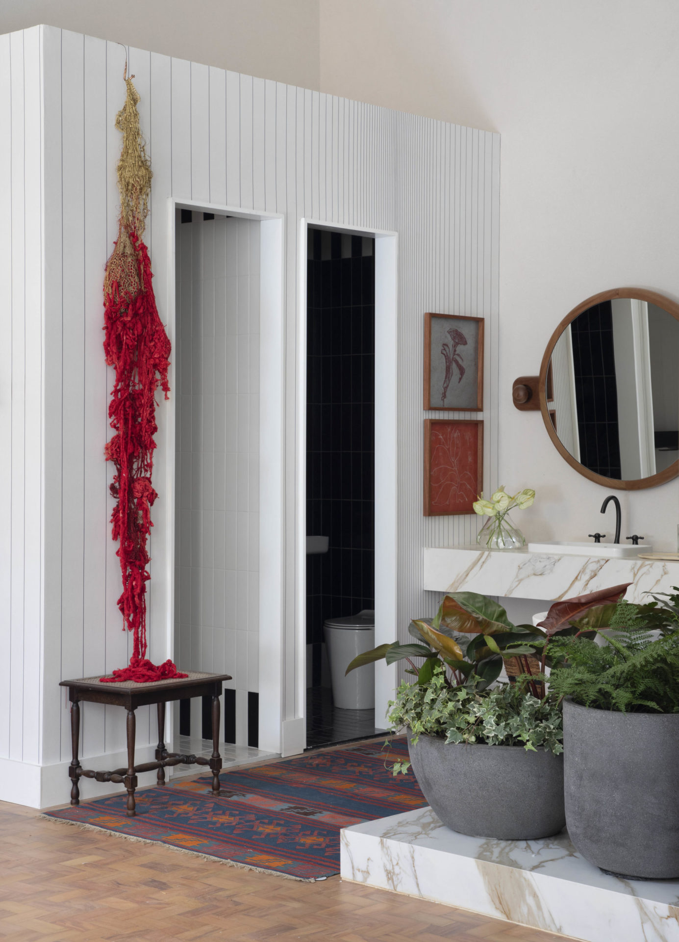 na foto banheiro de loft com obras de arte e texturas diferentes