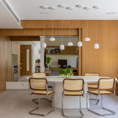 na foto sala de jantar integrada com cozinha e escritório. Todos os ambientes são separados por portas de correr de madeira