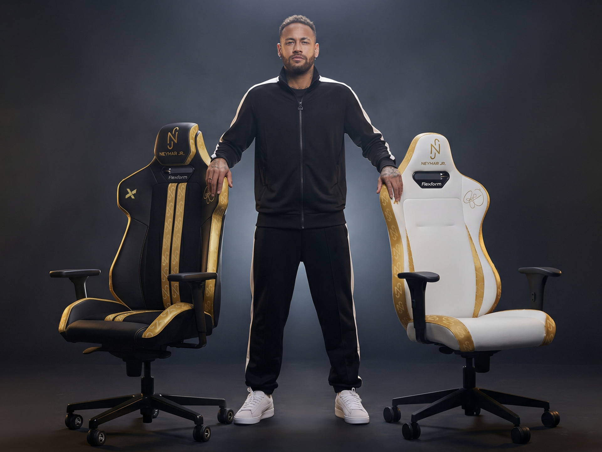na foto homem em pé entre duas cadeiras gamers