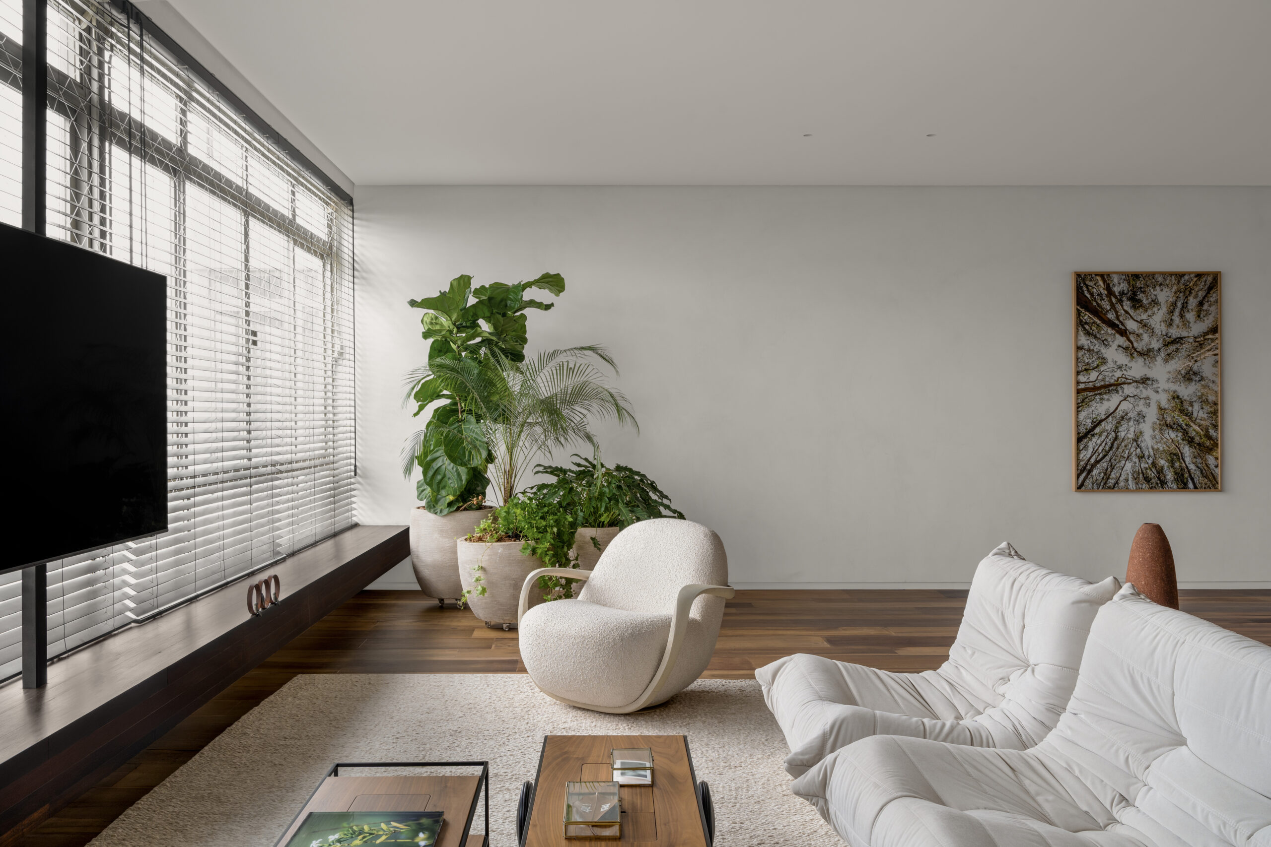 na foto sala com grande janela, sofá modular branco, mesinhas de centro