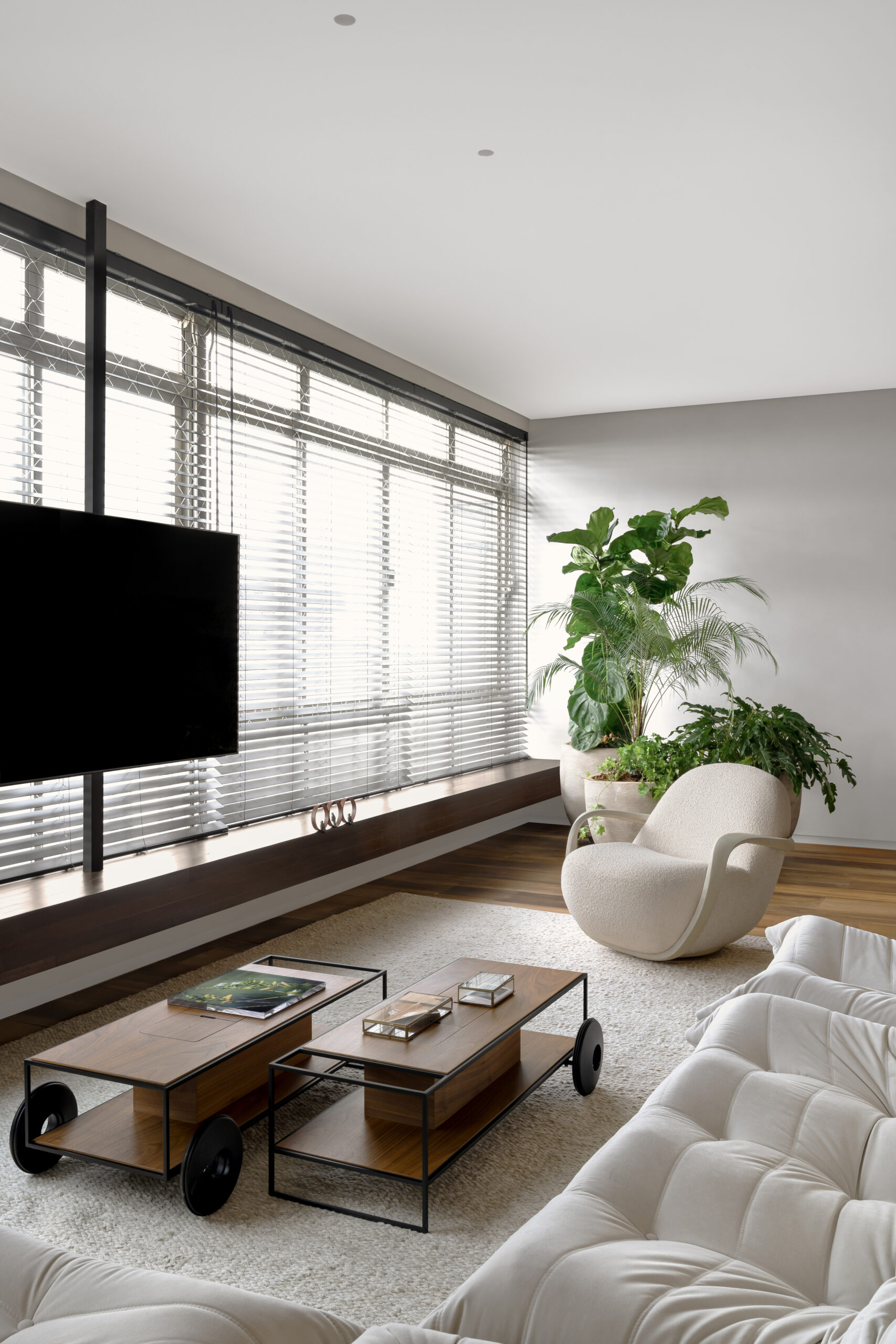 na foto sala com varanda, tv e banco de madeira