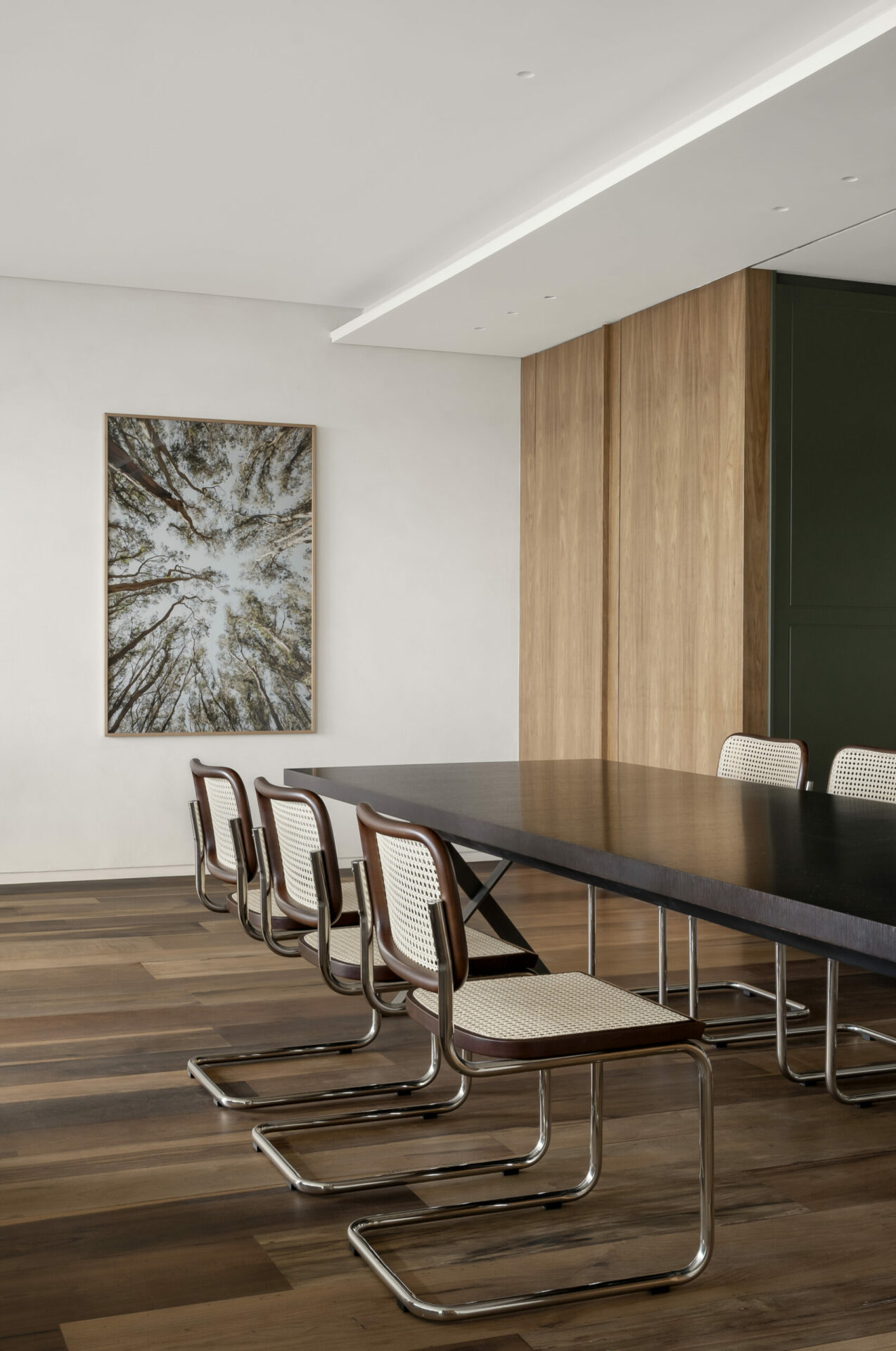na foto sala de jantar com grande mesa retangular e parte da cozinha