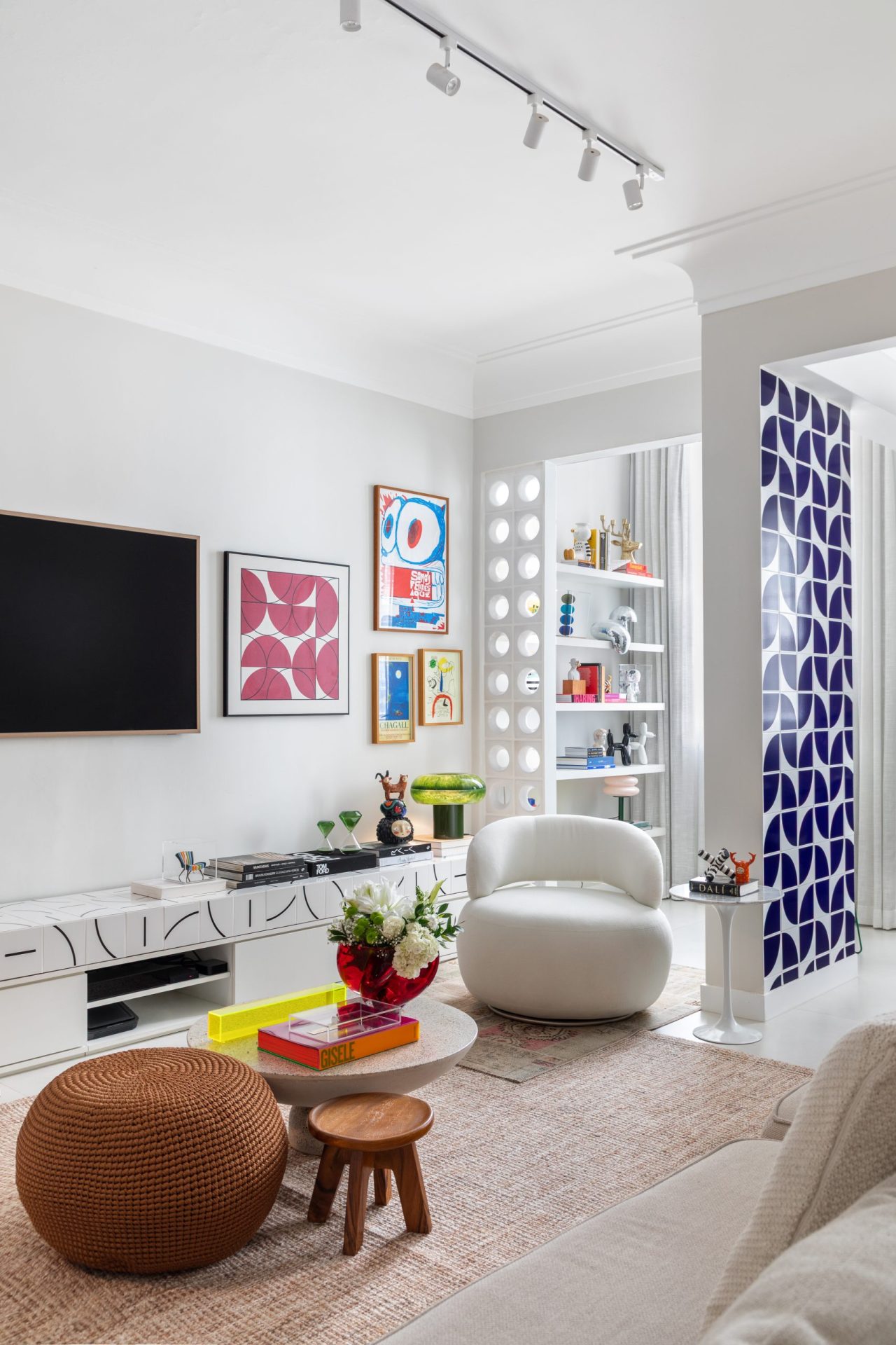 na foto sala de apartamento com tv, parede com azulejo e cobogó