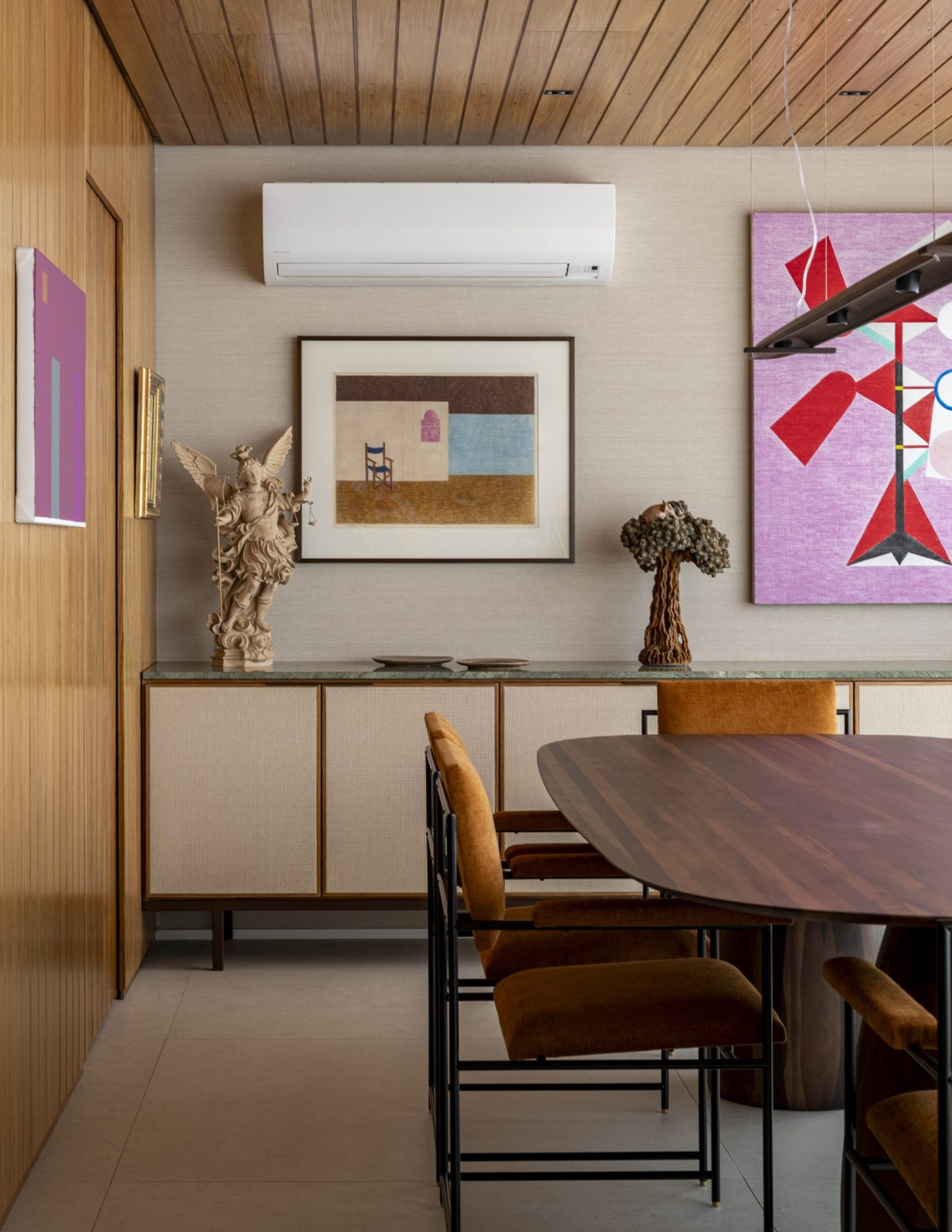 na foto sala de jantar com quadros na parede e mesa de jantar em madeira
