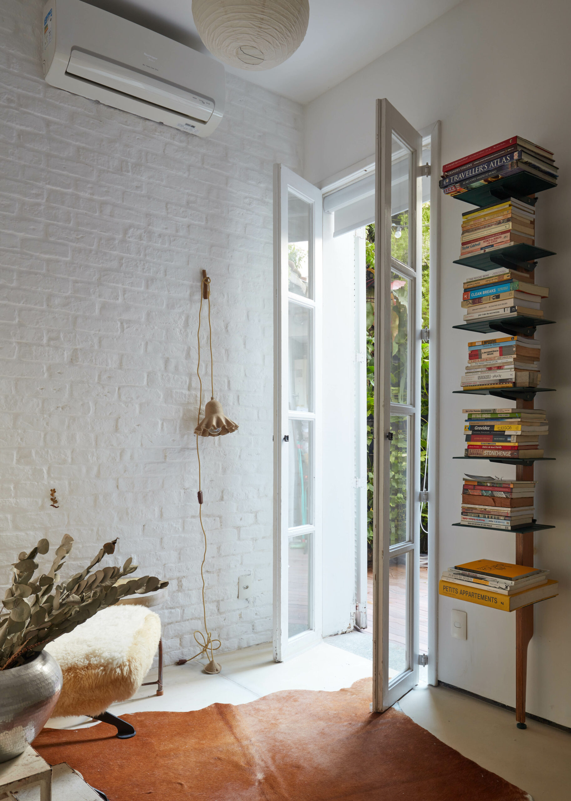 na foto ambiente com livros e porta para a parte externa do apartamento