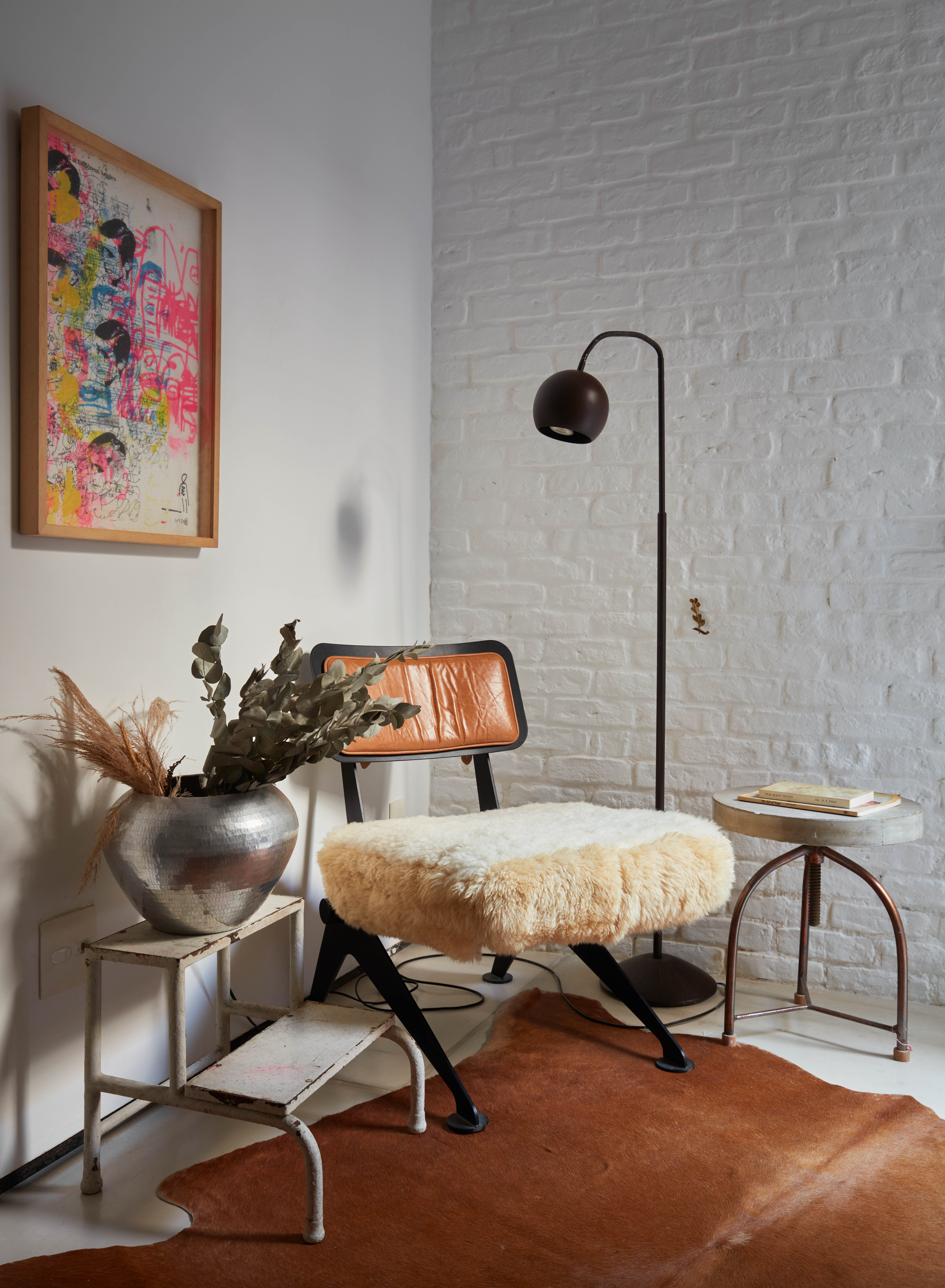 na foto ambiente de apartamento com uma cadeira, um quadro na parede e uma luminária no pé