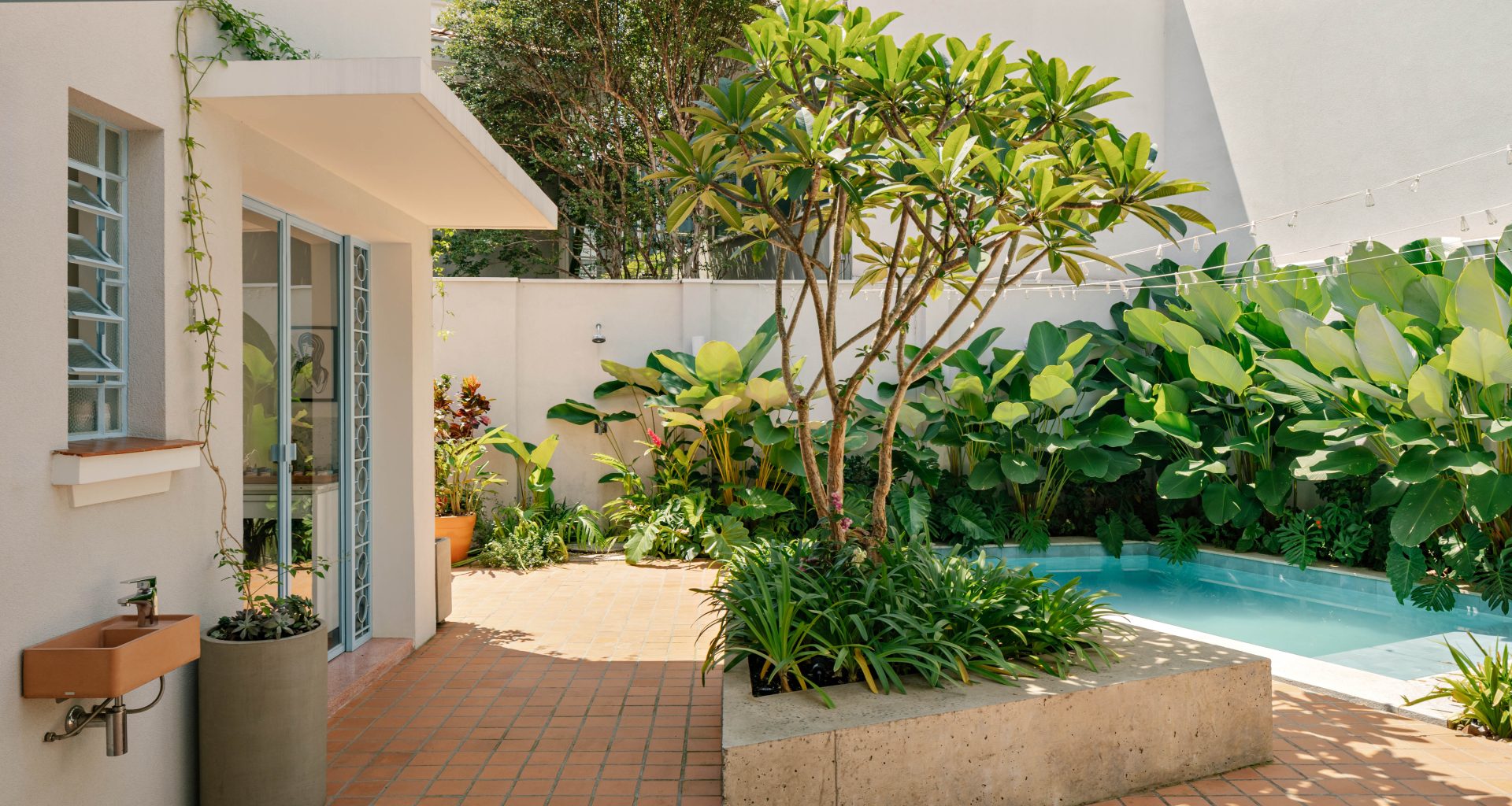na foto quintal de casa de vila com piscina e árvores