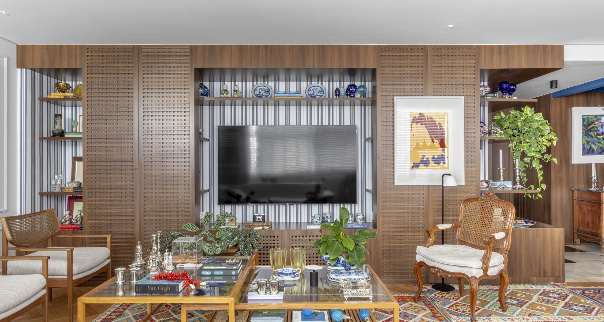 na foto sala com grande estante com objetos de decoração e espaço para TV