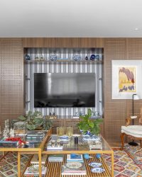 na foto sala com grande estante com objetos de decoração e espaço para TV