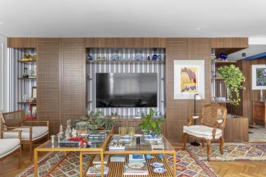na foto sala com grande estante com objetos de decoração e espaço para TV