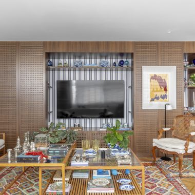 na foto sala com grande estante com objetos de decoração e espaço para TV