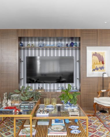 na foto sala com grande estante com objetos de decoração e espaço para TV