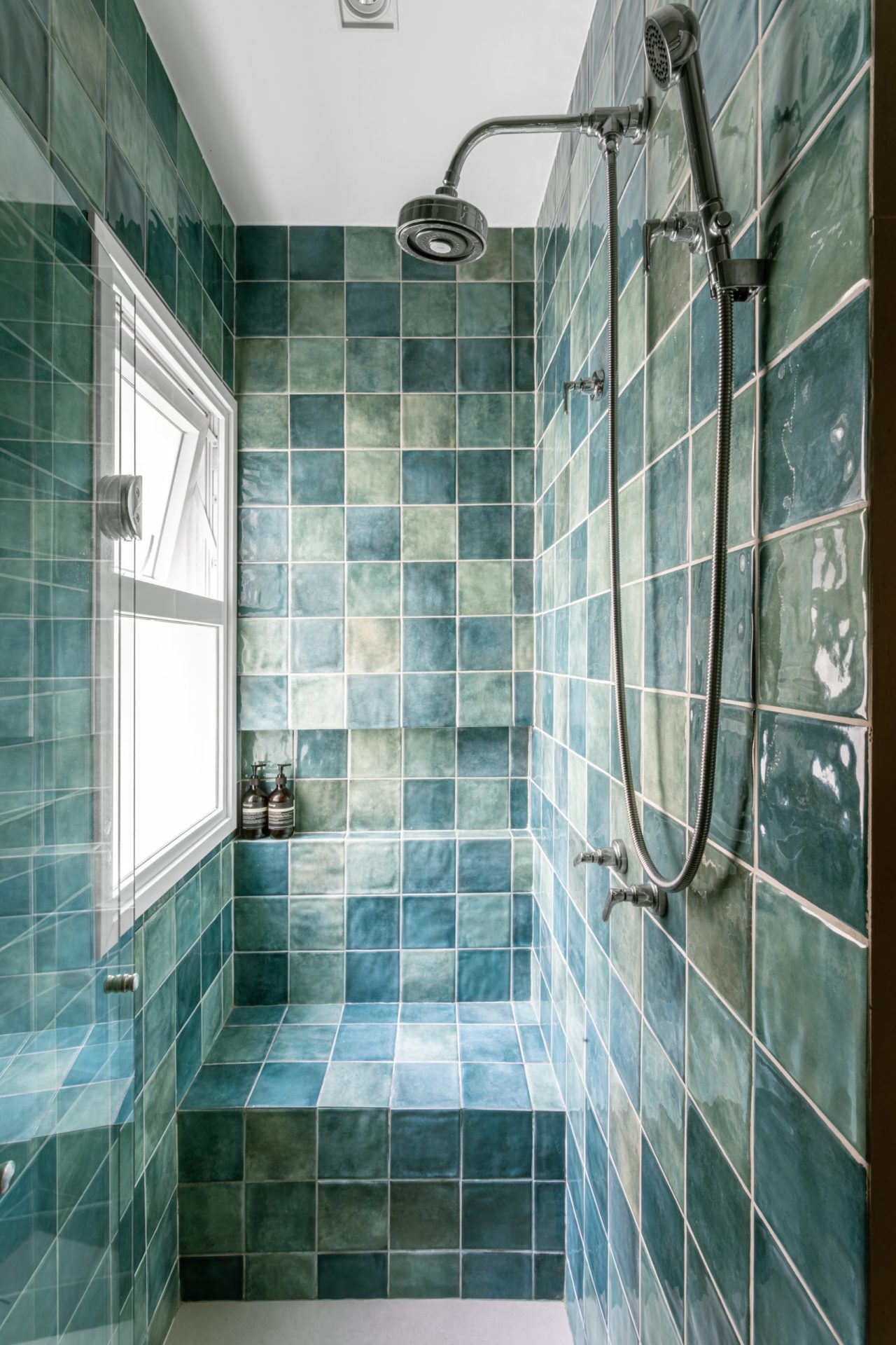 na foto banheiro de suíte com azulejos na cor azul