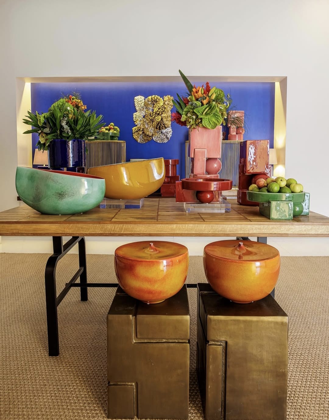 na foto espaço com mesa decorada com peças em cerâmica e porcelana em cores fortes 
