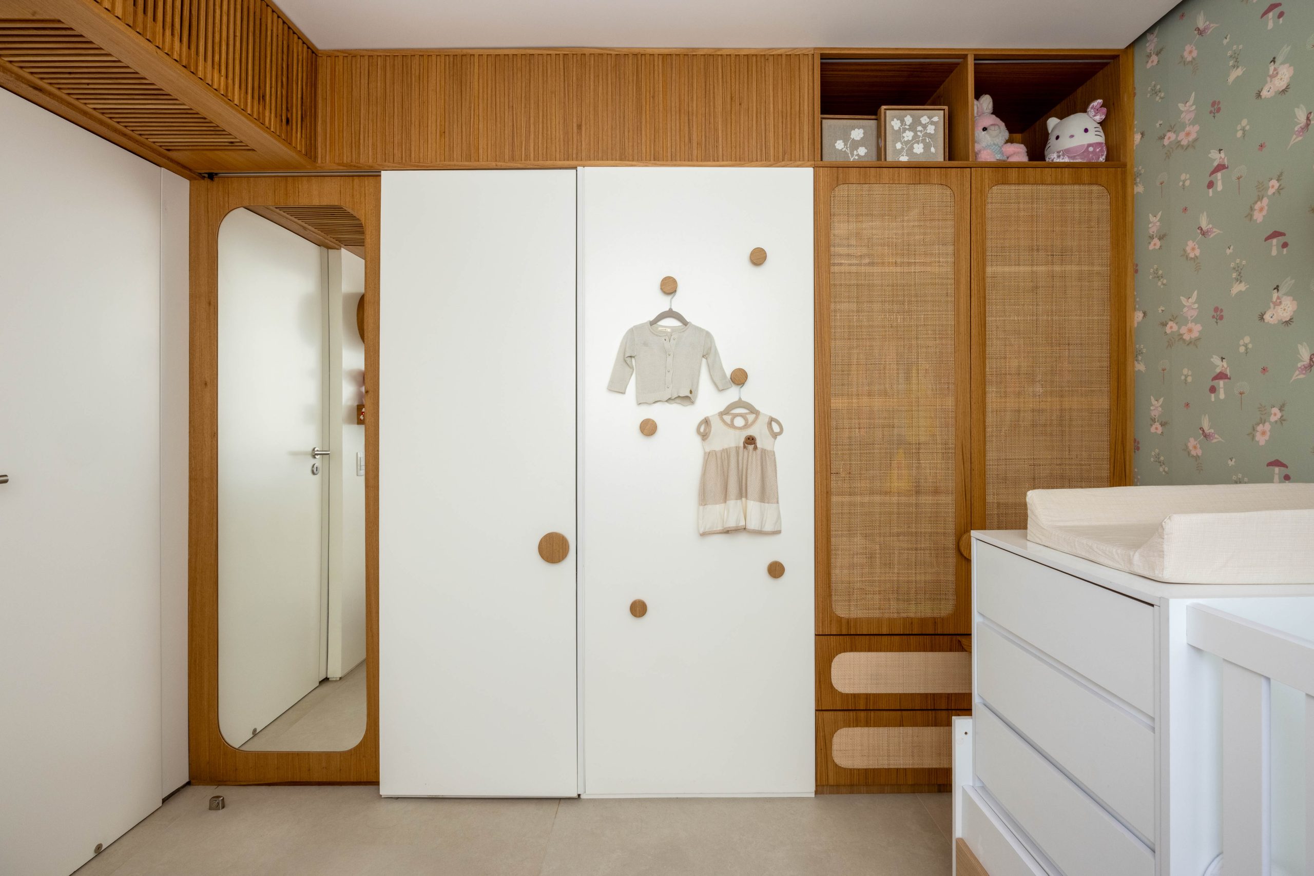 na foto quarto infantil com armário, espelho e berço. destaque para marcenaria.