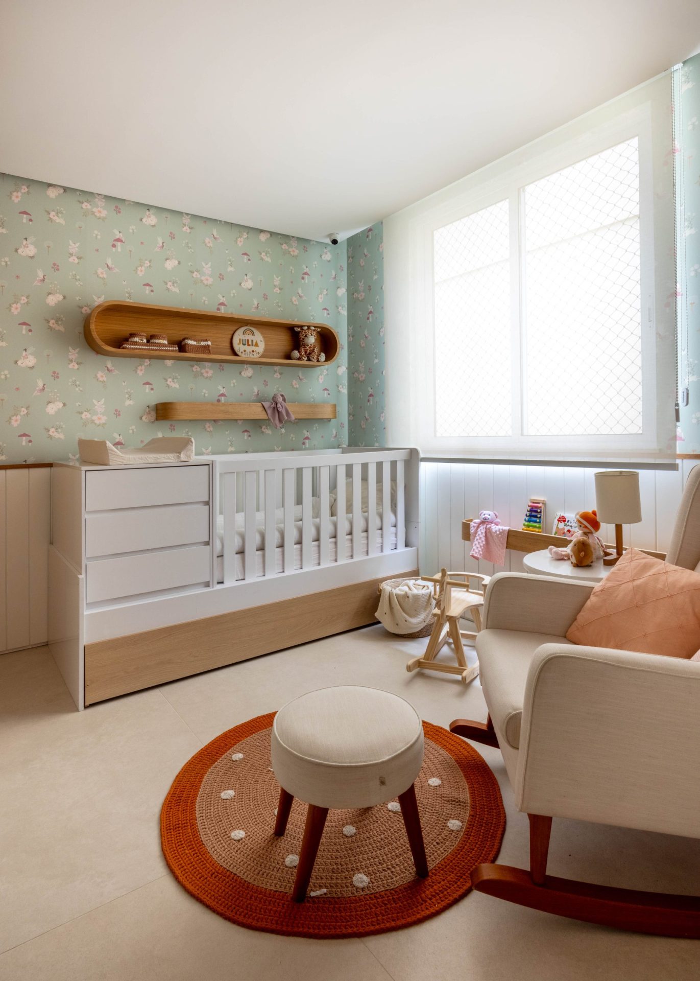 na foto quarto infantil com berço, cômoda, tapete colorido